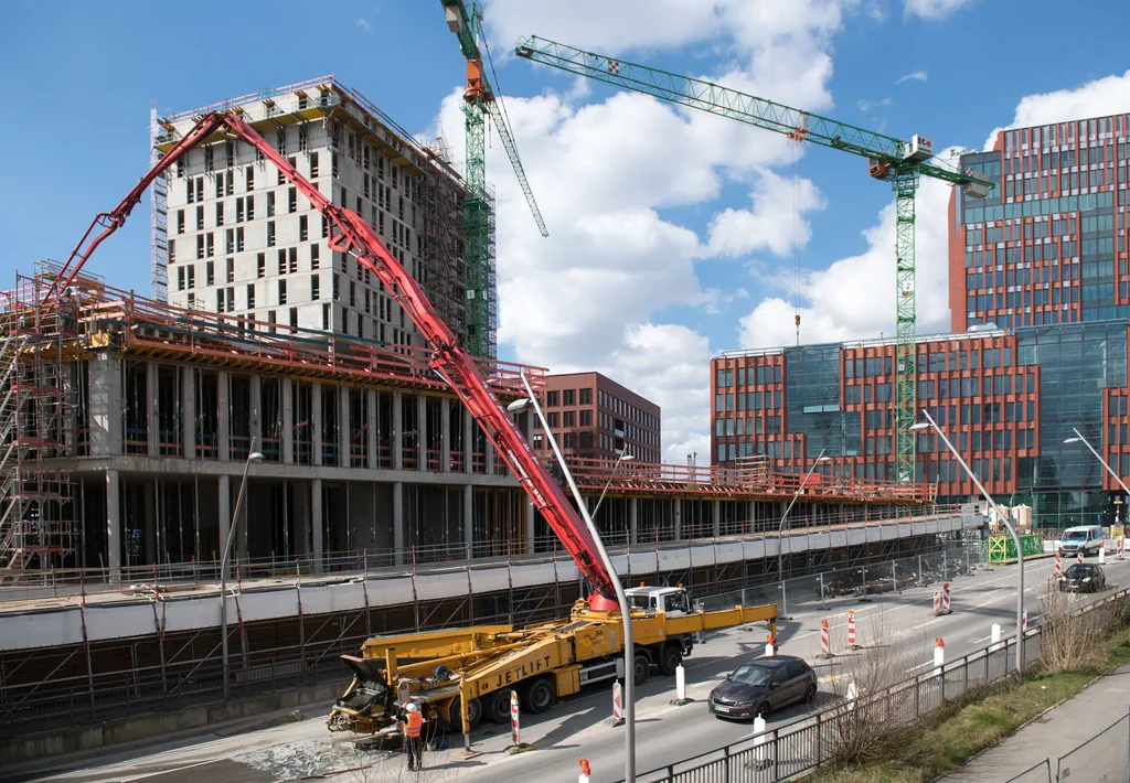 Șantier urban din Hamburg cu o structură în lucru și macarale.